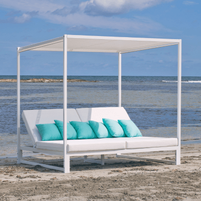 Resort parasol shading a Bali bed beside the pool