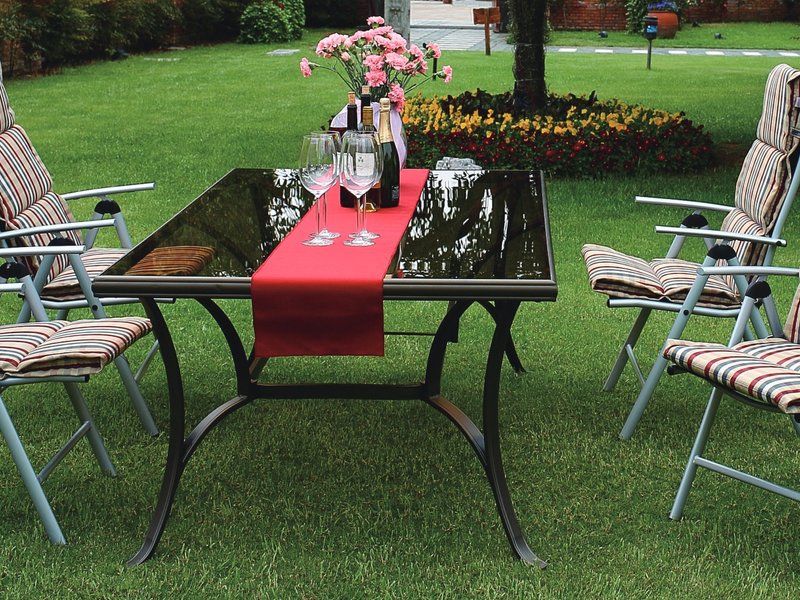 Striped dining chair cushions on metal folding chairs around a glass-top outdoor table