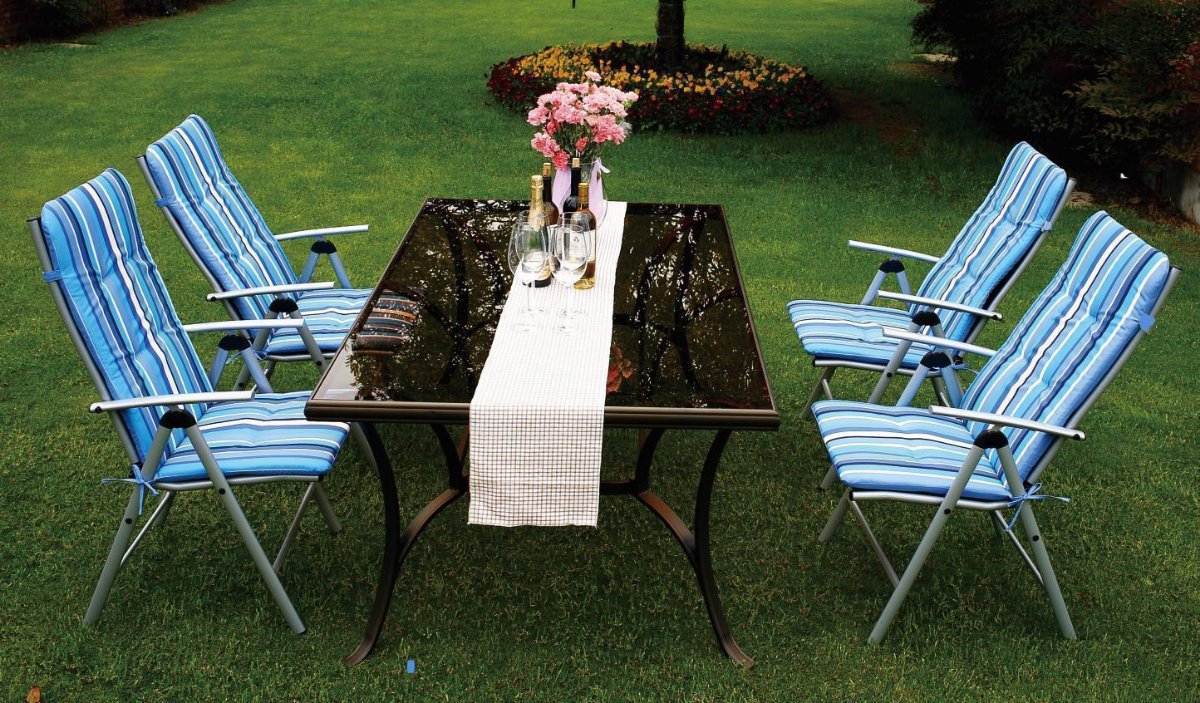 Blue and white striped outdoor cushions on chairs arranged around a table with flowers