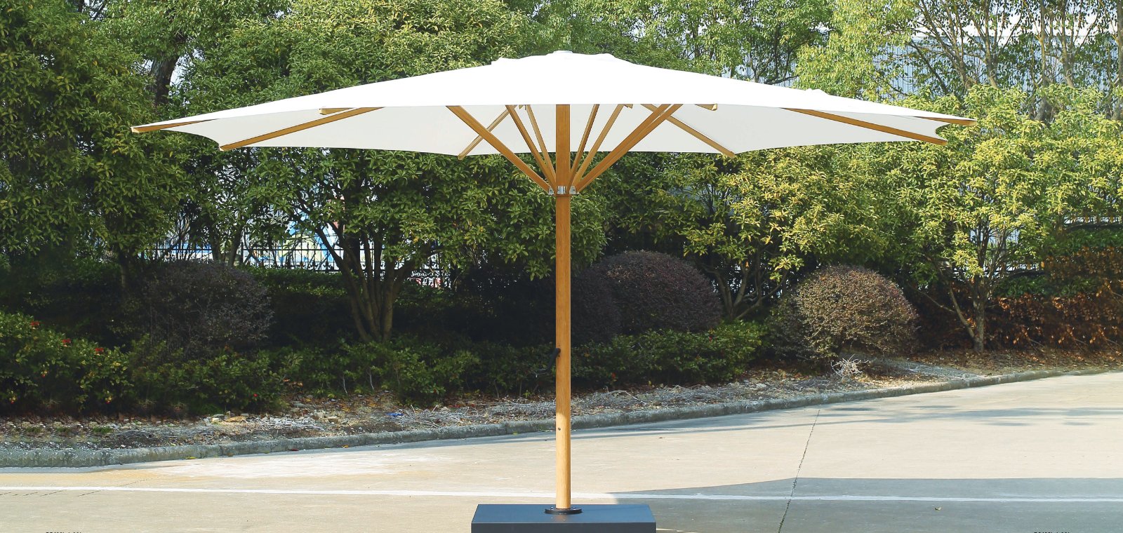 White umbrella with crank on a paved terrace